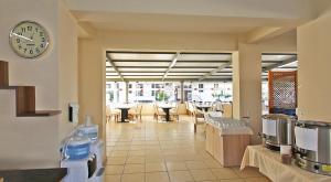 a restaurant with a clock on the wall and tables at Sare Hotel in Erdek +66 photos