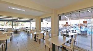 a restaurant with tables and chairs and windows at Sare Hotel in Erdek