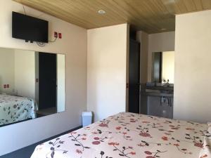 a bedroom with a bed and a mirror and a sink at Hotel Panamericano in Jocotitlán