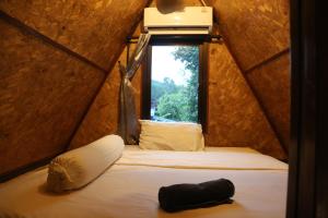 a bed in a small room with a window at Hidden Gem Elephant in Chiang Mai