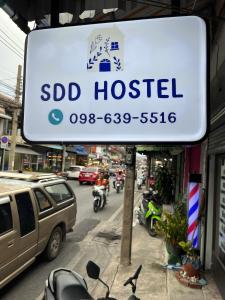 a sign for a hotel on a city street at SDD HoSTEL in Thung Si Kan