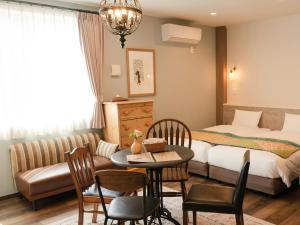 a hotel room with a bed and a table and chairs at 7 Rooms Hotel & Cafe - ディズニーと空港までバス1本 - 全室キッチン付き in Tokyo