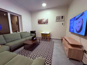 a living room with a couch and a flat screen tv at أوريانا oRIANA in Jeddah