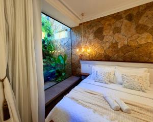 a bedroom with a bed and a large window at Chalé Jardim Itália em Tianguá in Tianguá +45 photos