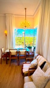 a living room with a chandelier and a large window at Chalé Jardim Itália em Tianguá in Tianguá