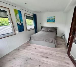 a bedroom with a bed and two windows at FeWo-Krone in Heringsdorf