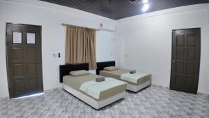 a bedroom with two beds and two doors at F&D Homestay in Semporna