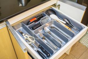 a tray with utensils in a kitchen sink at Voice activated studio condo unit at One Regis Megaworld, JK Modern Nest in Bacolod