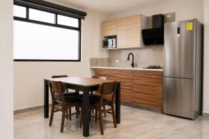 a kitchen with a table and a stainless steel refrigerator at Loft Ejecutivo San Martin Centro Wifi Tv 65 in San Martín Texmelucan de Labastida +4 photos