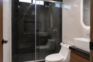 a bathroom with a shower and a toilet and a sink at Loft Ejecutivo San Martin Centro Wifi Tv 65 in San Martín Texmelucan de Labastida