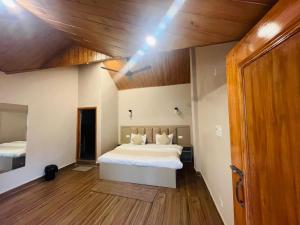 a bedroom with a bed and a wooden ceiling at HOTEL DEVDAR RESORT in Dharmsāla