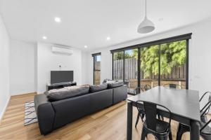 a living room with a couch and a table at Sleek Contemporary Haven Geelong in Highton