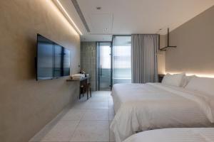 a hotel room with a bed and a flat screen tv at 晴井villa in Huxi