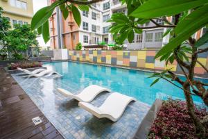 a swimming pool with lounge chairs in a building at Voice activated studio condo unit at One Regis Megaworld, JK Modern Nest in Bacolod