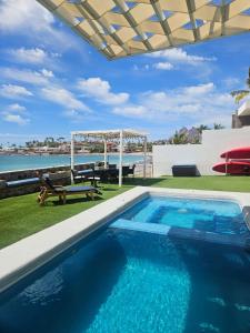 a swimming pool with a gazebo and the ocean at Vista Delfin Beach House in San Carlos