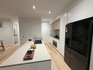 a kitchen with a white counter top and a black refrigerator at Papillon Home in Rockbank