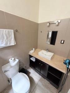 un bagno con un WC bianco e un lavandino di Casa Koru a Palenque