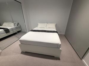 a white bed in a room with a mirror at Papillon Home in Rockbank +81 photos