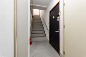 a hallway with stairs and a black door at Darin中洲北 2F in Fukuoka +30 photos