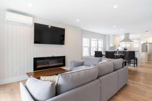 a living room with a couch and a tv at Beautiful and Spacious 3BD Condo in Somerville in Somerville