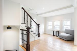 a living room with a staircase and a couch at Beautiful and Spacious 3BD Condo in Somerville in Somerville