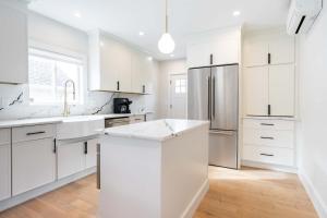 a white kitchen with white cabinets and a refrigerator at Beautiful and Spacious 3BD Condo in Somerville in Somerville +51 photos
