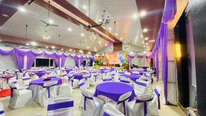 a banquet hall with purple and white tables and chairs at HOTEL DEVDAR RESORT in Dharmsāla