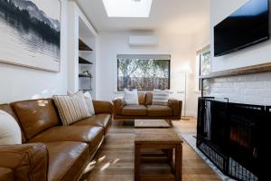 a living room with a couch and a fireplace at Garden Cottage, Wellness Studio & Bike Shed in Winnaleah
