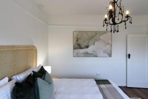 a bedroom with a bed and a chandelier at Garden Cottage, Wellness Studio & Bike Shed in Winnaleah