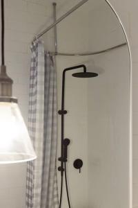 a shower with a glass door with a curtain at Garden Cottage, Wellness Studio & Bike Shed in Winnaleah +34 photos