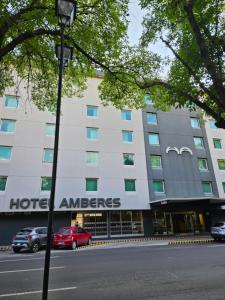 a hotel entrance with cars parked in front of a building at Hotel Amberes in Querétaro +5 photos