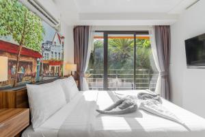 a bedroom with a white bed with a large window at Beachside 1BR Condo Pool Gym Phuket- MBC C172 in Ban Bo Sai Klang