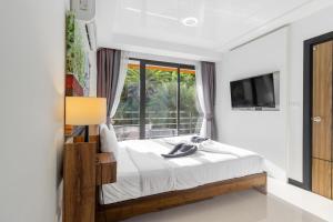 a bedroom with a bed and a tv and a window at Beachside 1BR Condo Pool Gym Phuket- MBC C172 in Ban Bo Sai Klang +27 photos