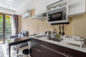 a kitchen with a sink and a microwave at Beachside 1BR Condo Pool Gym Phuket- MBC C172 in Ban Bo Sai Klang