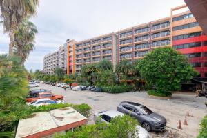 a parking lot with cars parked in front of a building at Beachside 1BR Condo Pool Gym Phuket- MBC C172 in Ban Bo Sai Klang