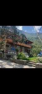 a house on a hill with a mountain in the background at Briddhim Guest House in Syābru Bensi