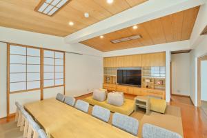 a large dining room with a table and a tv at Yunokawa Kagura in Hakodate