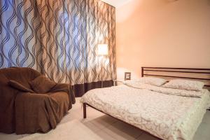a bedroom with a bed and a chair at Studio Ember at Maidan Konstytutsii in Kharkiv