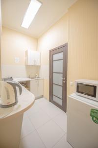 a room with a kitchen with a microwave and a door at Studio Ember at Maidan Konstytutsii in Kharkiv