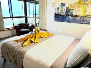 a bedroom with a bed with yellow towels on it at Sunsethome Wallaroo in Wallaroo