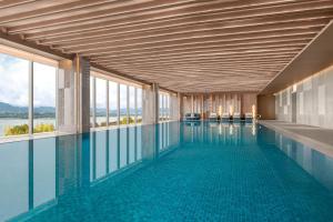 a swimming pool with a view of the water at The Westin Yichang in Yichang