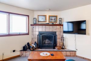 a living room with a fireplace and a table at Ski Bowl Cottage! in Hunter