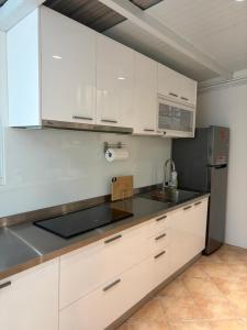 a kitchen with white cabinets and a black counter top at DayBreak 2 in Taitung City