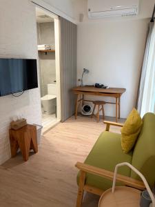a living room with a green couch and a television at DayBreak 2 in Taitung City
