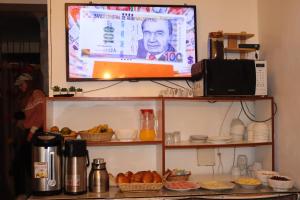 a flat screen tv hanging on a wall with food at Machupicchu Royal Mountain in Machu Picchu