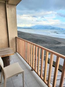 a balcony with a table and a chair and the beach at Puffer Isle Resort in Dingalan