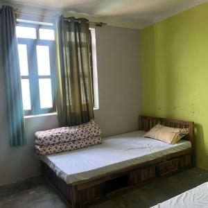 a small bed in a room with a window at Briddhim Guest House in Syābru Bensi +19 photos