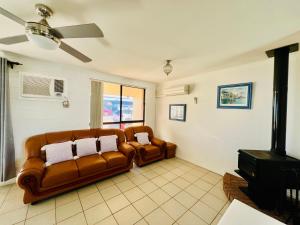 a living room with two leather couches and a stove at Sunsethome Wallaroo in Wallaroo