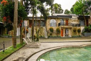 a house with a chair in front of a swimming pool at Nimo Resort Ciater in Ciater