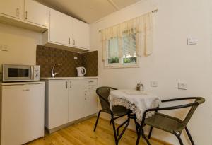 a kitchen with a table and two chairs and a microwave at Orna's Corner in Yuval